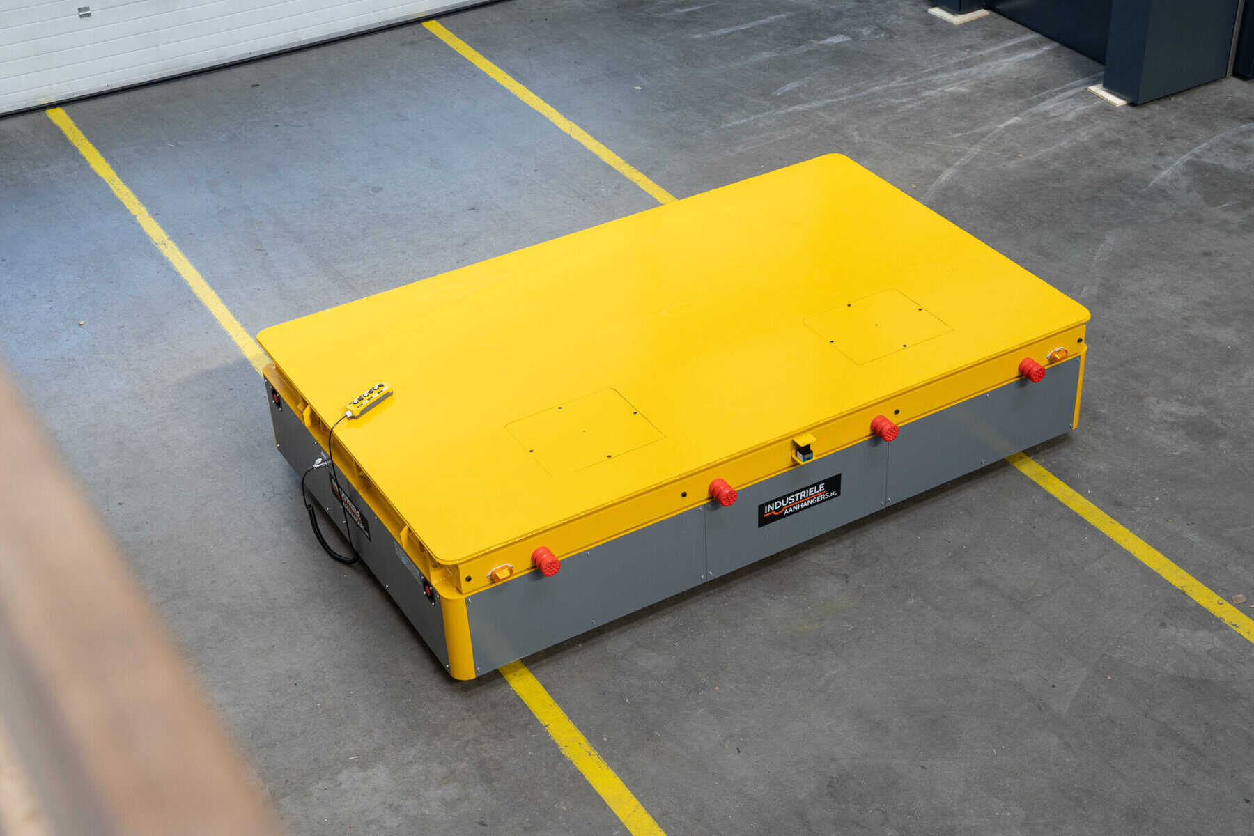 Yellow HULCK platform mover with remote control on a factory floor