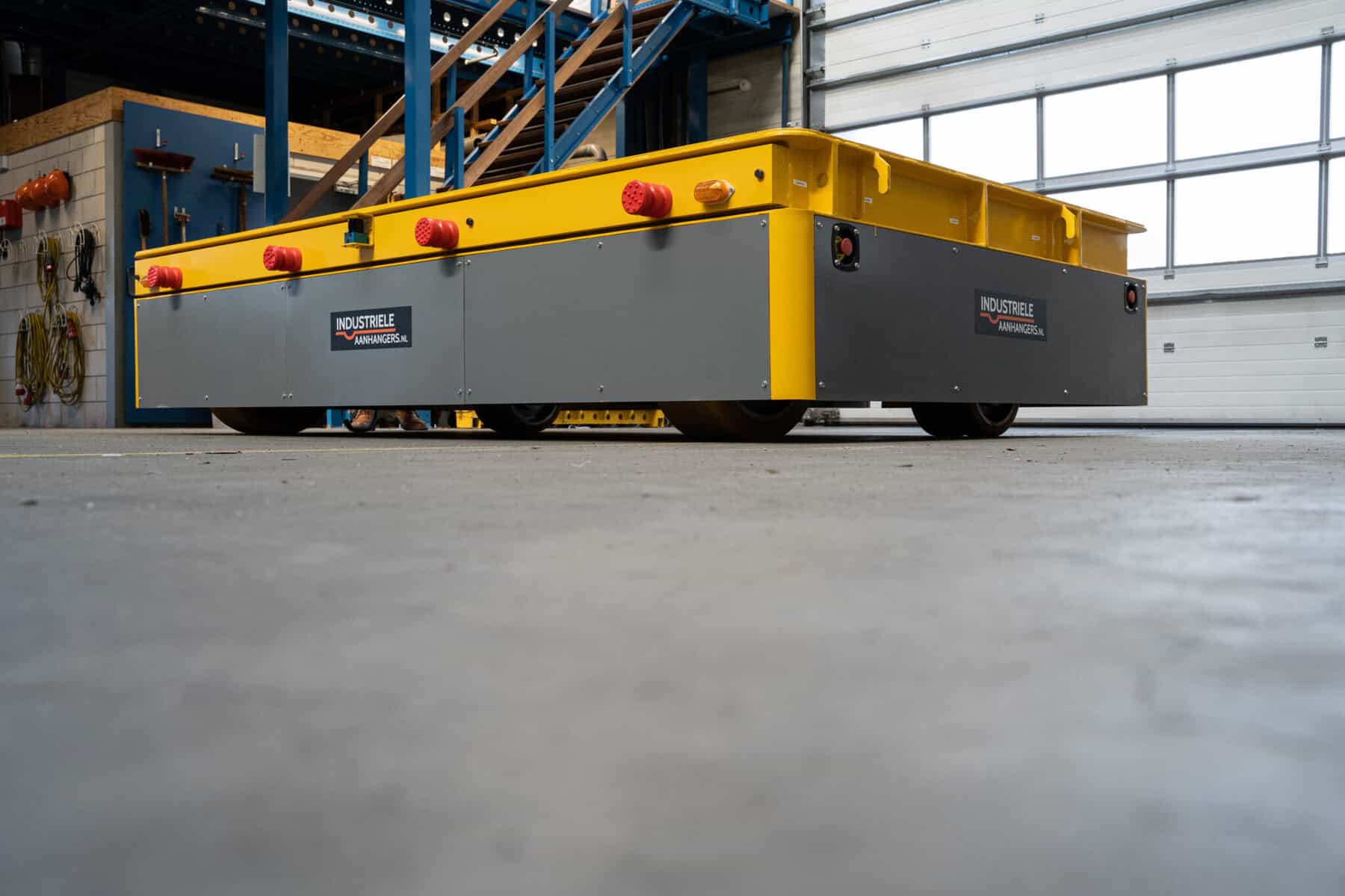 Low-profile yellow HULCK platform mover showing heavy-duty wheels in a workshop